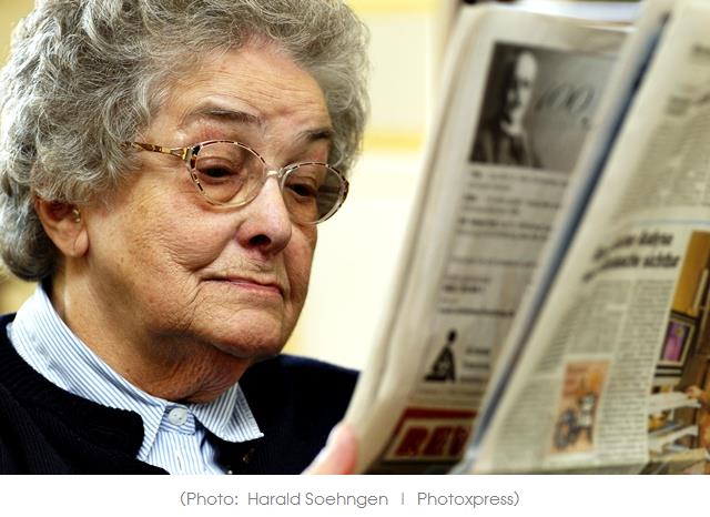 Old woman reading newspaper.